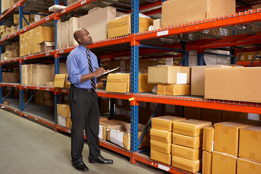 Businessman With Clipboard In Warehouse